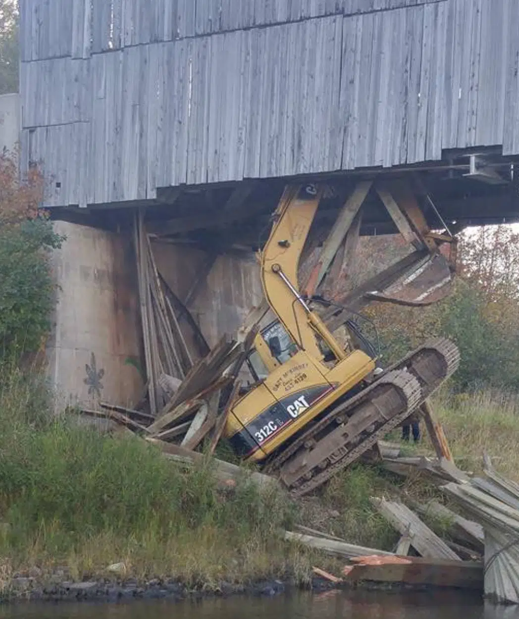 Excavator Crashes Through Floor Of Historic Covered Bridge