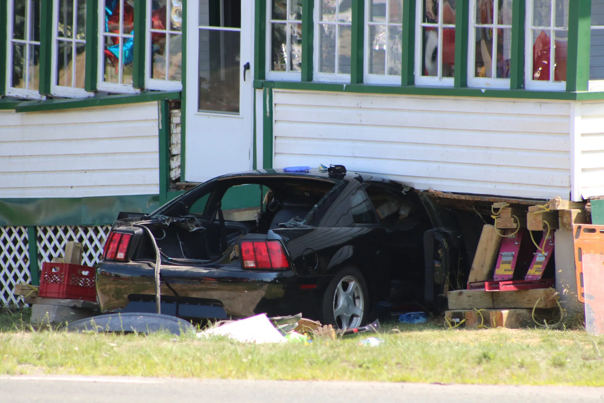 Road open after car collides with home, two people taken to hospital