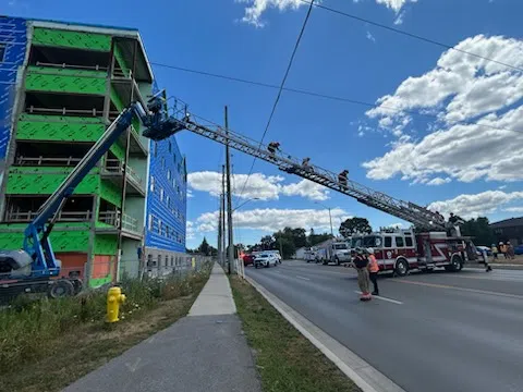 Two workers rescued after genie lift hits wires along Sidney Street