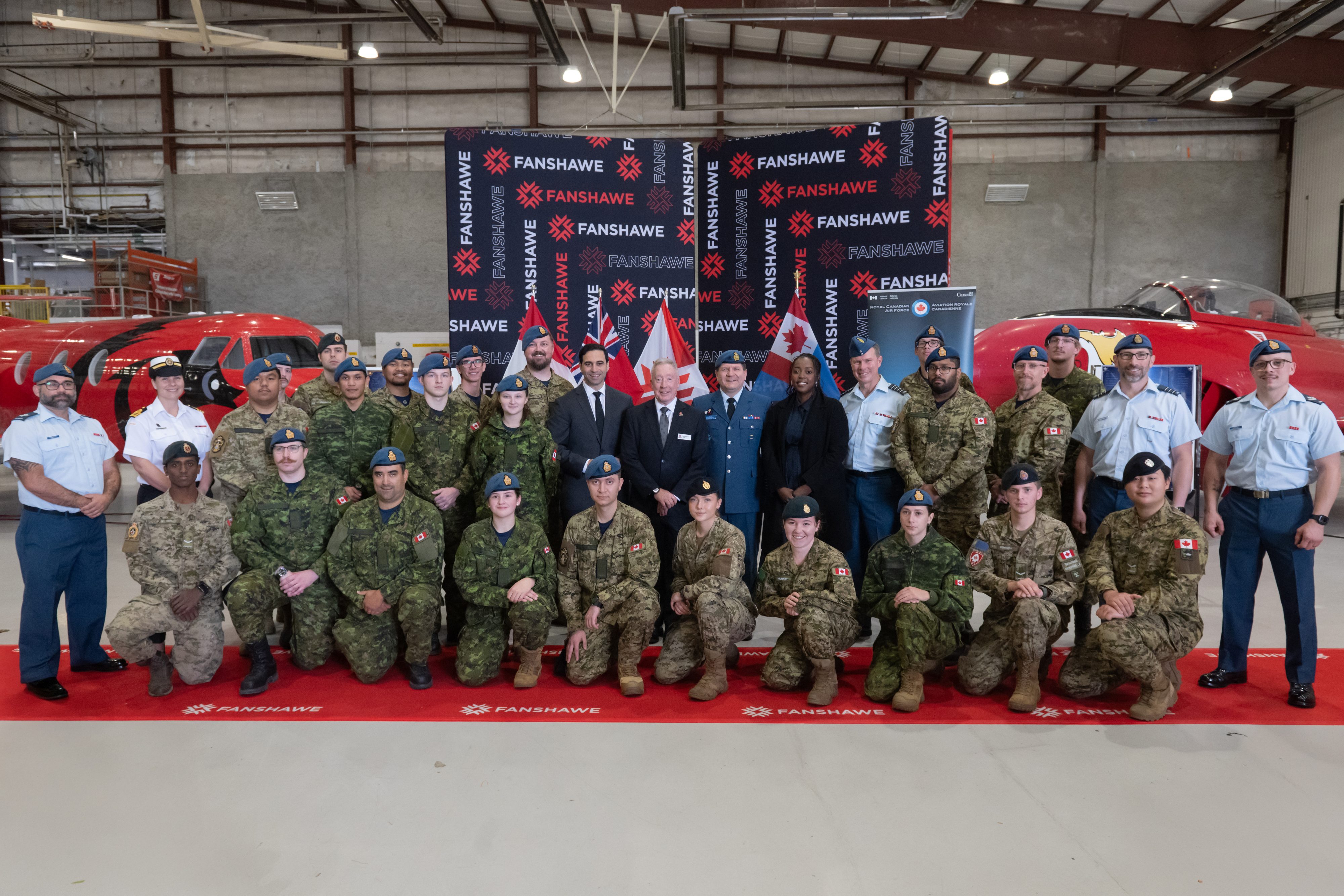 Fanshawe and government officials stand among members of the Canadian Armed Forces in uniform at announcement