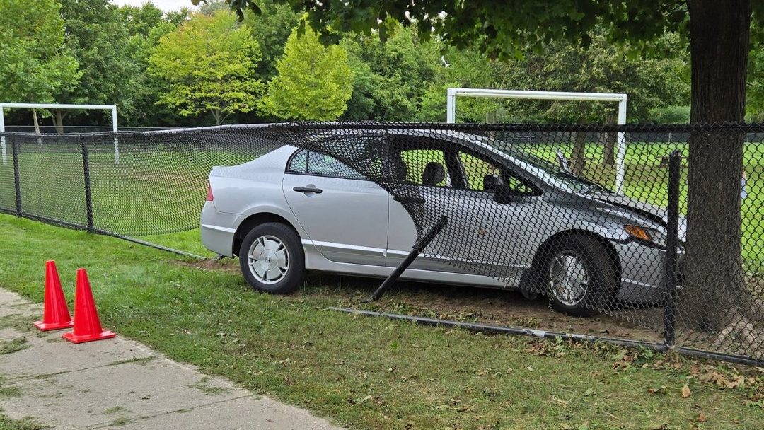 Charges laid after motorist drives through fence of Cambridge school