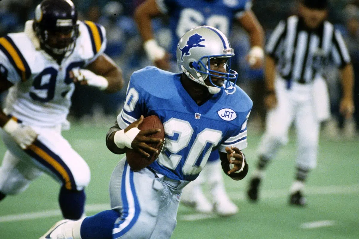 Barry Sanders running with a football.