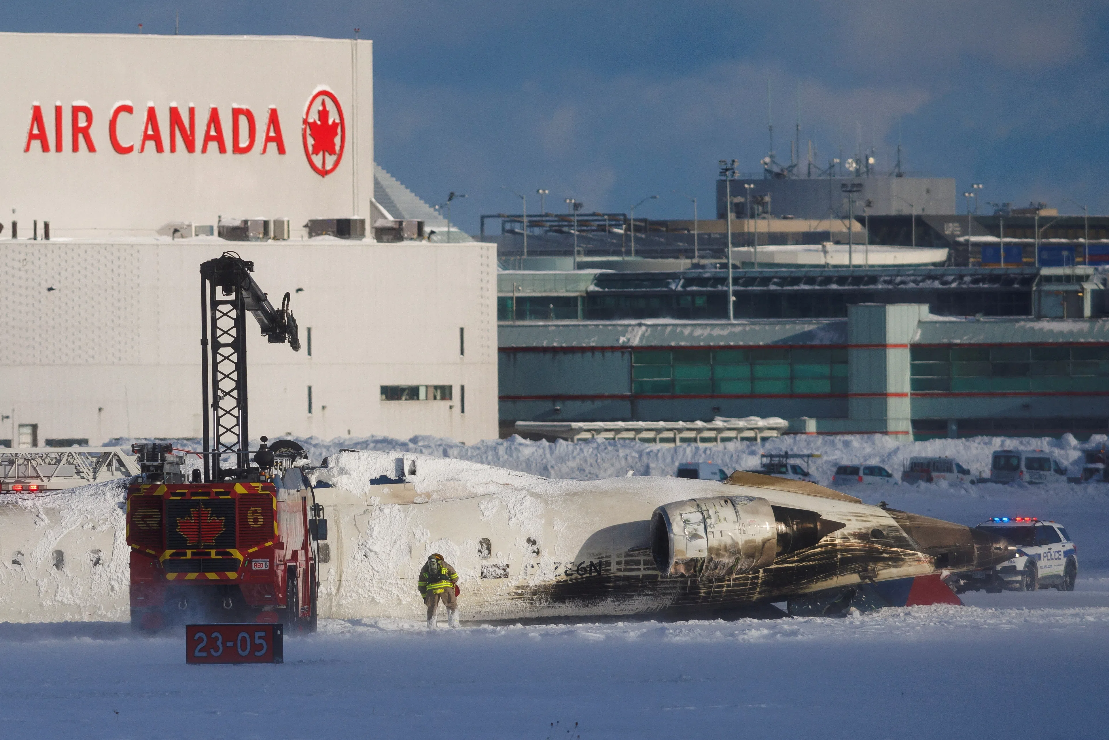 An emergency responder works around an aircraft on a runway, after a plane crash at Toronto Pearson International Airport in Mississauga, Ontario, Canada February 17, 2025. REUTERS/Cole Burston REUTERS/Cole Burston