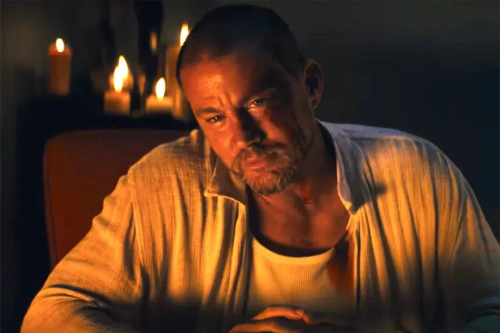 Channing Tatum dimly lit as he leans onto a table