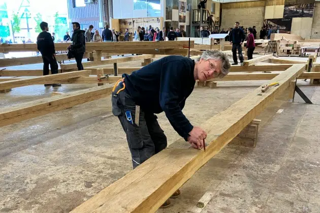 Peter Henrikson, 61, a timber framer from Minnesota, measures a beam, part of the new roof of the Notre Dame cathedral de Paris, Thursday, May, 25, 2023., near Angers, western France. Carpenters building a new timber frame for the fire-ravaged roof of Paris' Notre Dame Cathedral are using the same tools and techniques as their medieval predecessors. For them, working with hand-axes to fashion oak beams has been like stepping back in time.