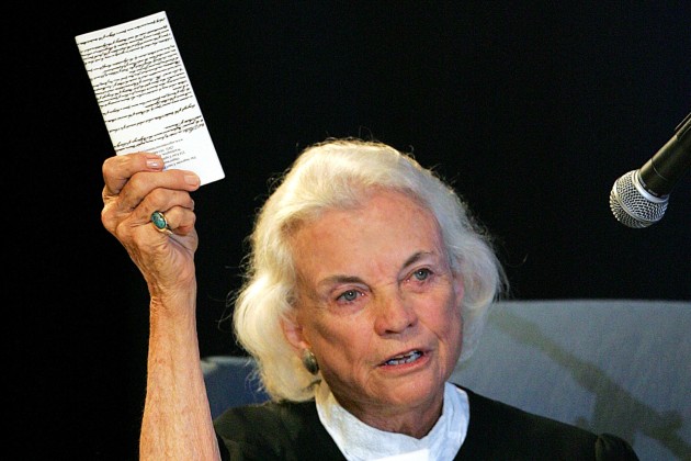 FILE - U.S. Supreme Court Justice Sandra Day O'Connor hold up a copy of the U.S. constitution that she carries with her Saturday, Sept. 17, 2005 at an open-air Immigration and Naturalization citizenship hearing in Gilbert, Ariz.