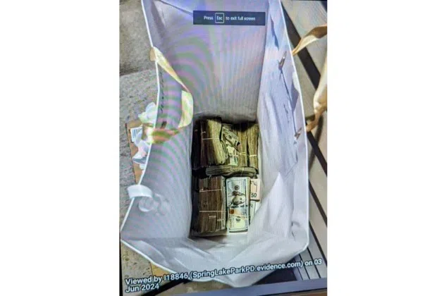 This photo supplied by the U.S. Attorney's Office for Minnesota shows cash from a bag that was left at the home of a juror in a massive fraud case, June 2, 2024, outside Minneapolis, Minn. Authorities have confiscated cellphones and taken all seven defendants into custody as investigators try to determine who attempted to bribe the juror to acquit them on charges of stealing more than $40 million from a program meant to feed children during the pandemic.