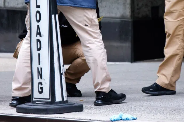 Members of the New York police crime scene unit investigate bullets lying on the sidewalk at the scene outside the Hilton Hotel in midtown Manhattan where Brian Thompson, the CEO of UnitedHealthcare, was fatally shot, Wednesday, Dec. 4, 2024, in New York.