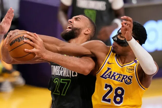 Minnesota Timberwolves center Rudy Gobert, left grabs a rebound next to Los Angeles Lakers forward Rui Hachimura (28) during the first half in Game 5 of an NBA basketball first-round playoff series Wednesday, April 30, 2025, in Los Angeles.