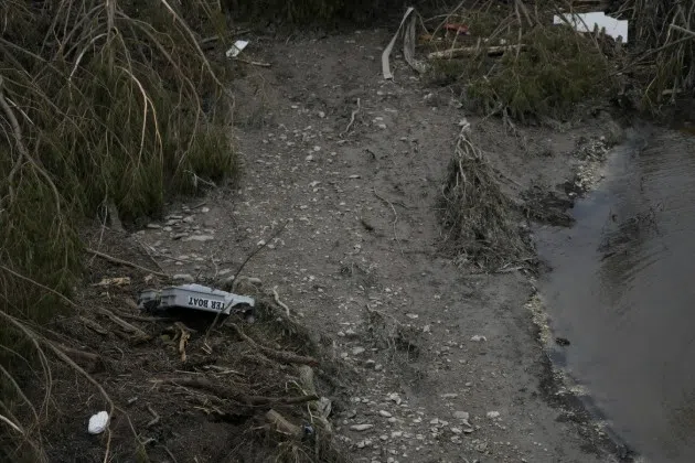 Debris is scattered by the river bed after flooding in Kerrville, Texas, Monday, July 7, 2025.
