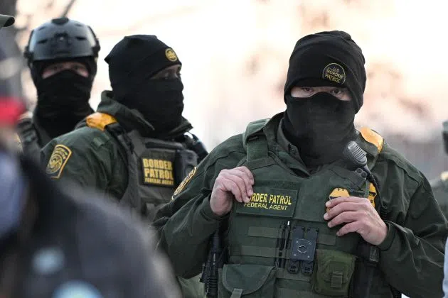 Federal agents look on as protesters gather outside the Bishop Henry Whipple Federal Building, Thursday, Jan. 8, 2026, in Minneapolis, Minn.