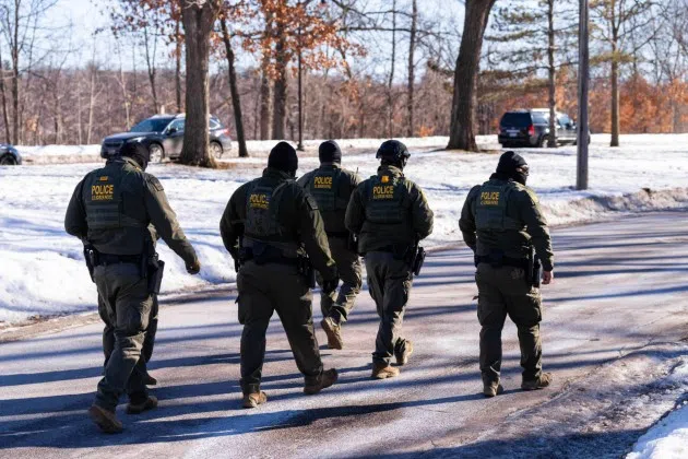 FILE - U.S. Border Patrol officers walk along a street in Minneapolis, Wednesday, Jan. 14, 2026.