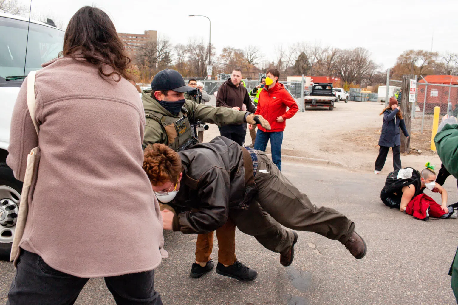 A homeland security agent throws a demonstrator onto the ground as they attempt to block vehicles during a federal raid at Bro-Tex, a paper distributor St. Paul Tuesday, Nov. 18, 2025. (Photo by Nicole Neri/Minnesota Reformer)