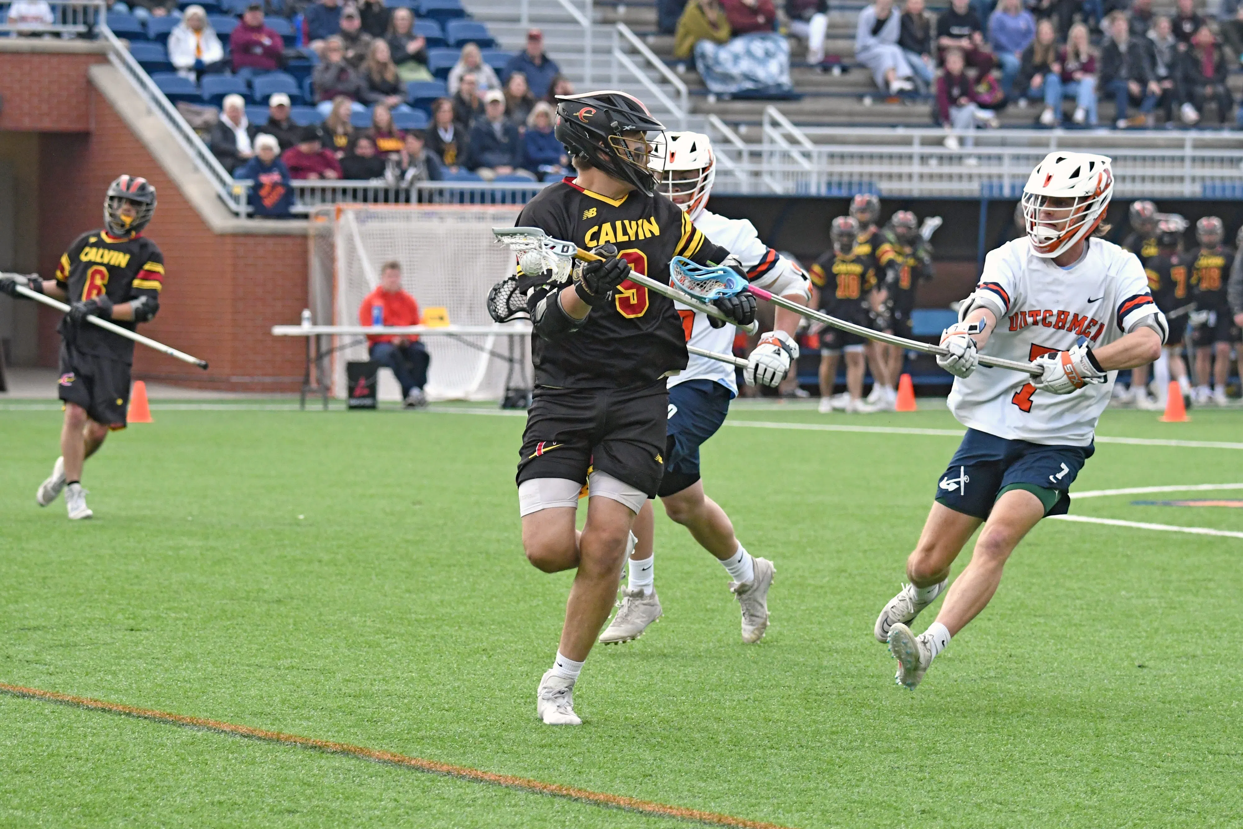 Hope College long-stick midfielder Luke Wierengo defends against Calvin.