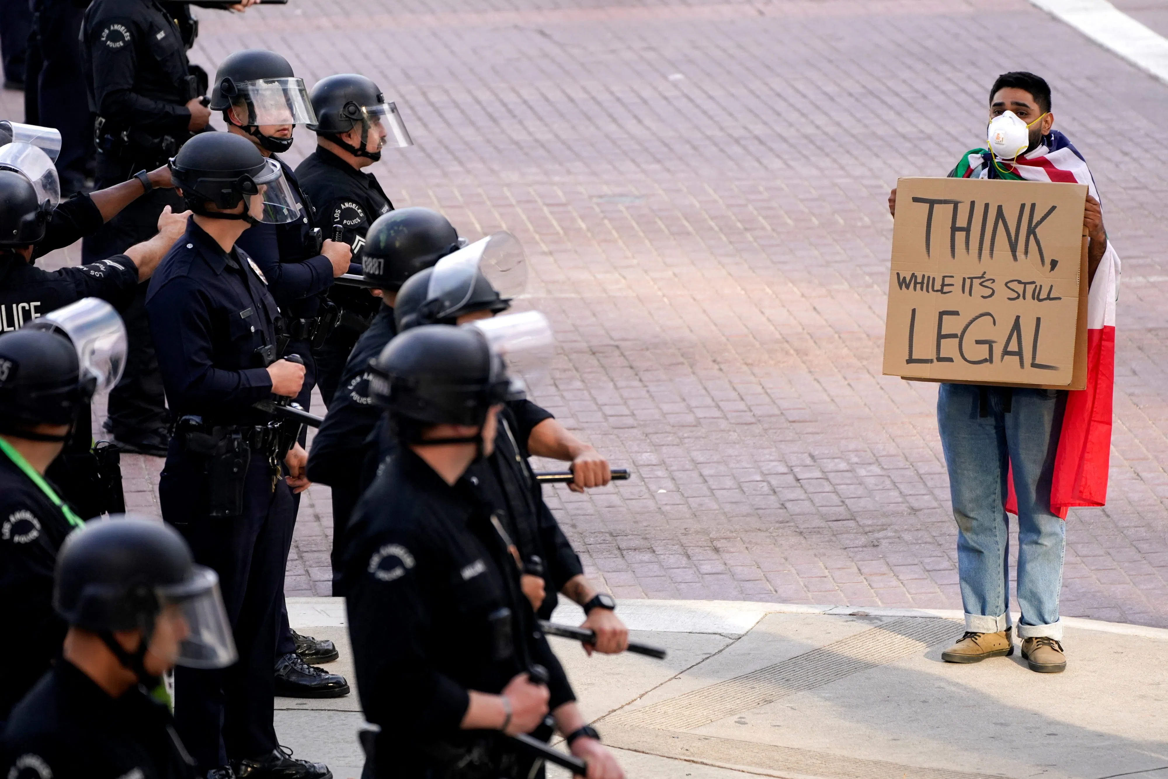 A demonstator holds a sign in front of police officers during protest against U.S. President Donald Trump's policies and federal immigration sweeps during a No Kings Day demonstration in Los Angeles, California, U.S., June 14, 2025. REUTERS/David Ryder