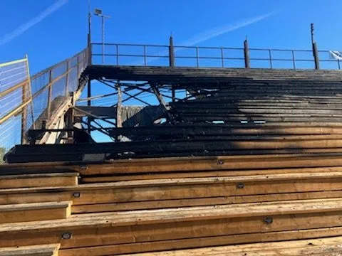 a big holeis burned in a section of bleachers 