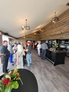 inside the restauant shows wood ceiling and indutrial style lights, big windows 