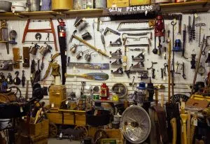 An entire wall of tools and outdoor equipment that have been mounted on the wall.