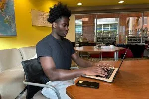 A student typing on his laptop at MRU’s campus Wyckham House.