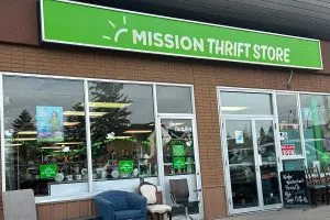 The exterior of Mission Thrift Store features chairs on sale outside of the shop.