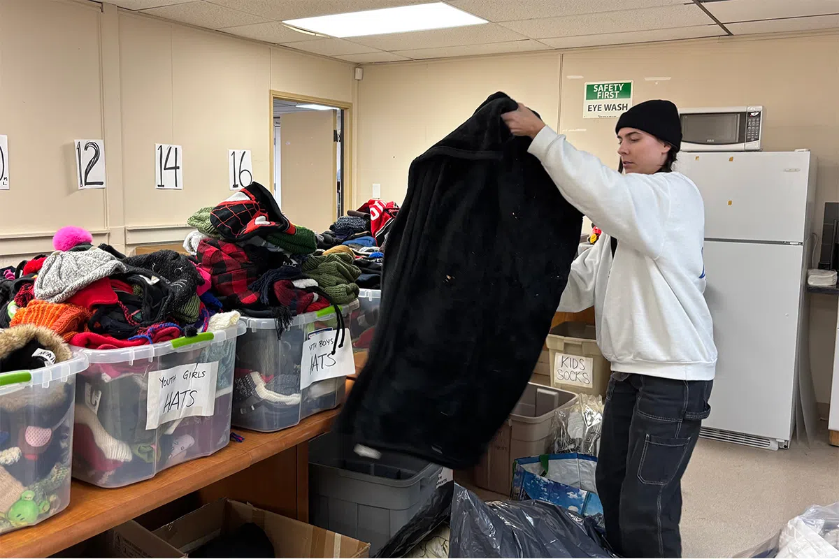 The interior of Project Warmth main building, featuring a volunteer sorting through donations