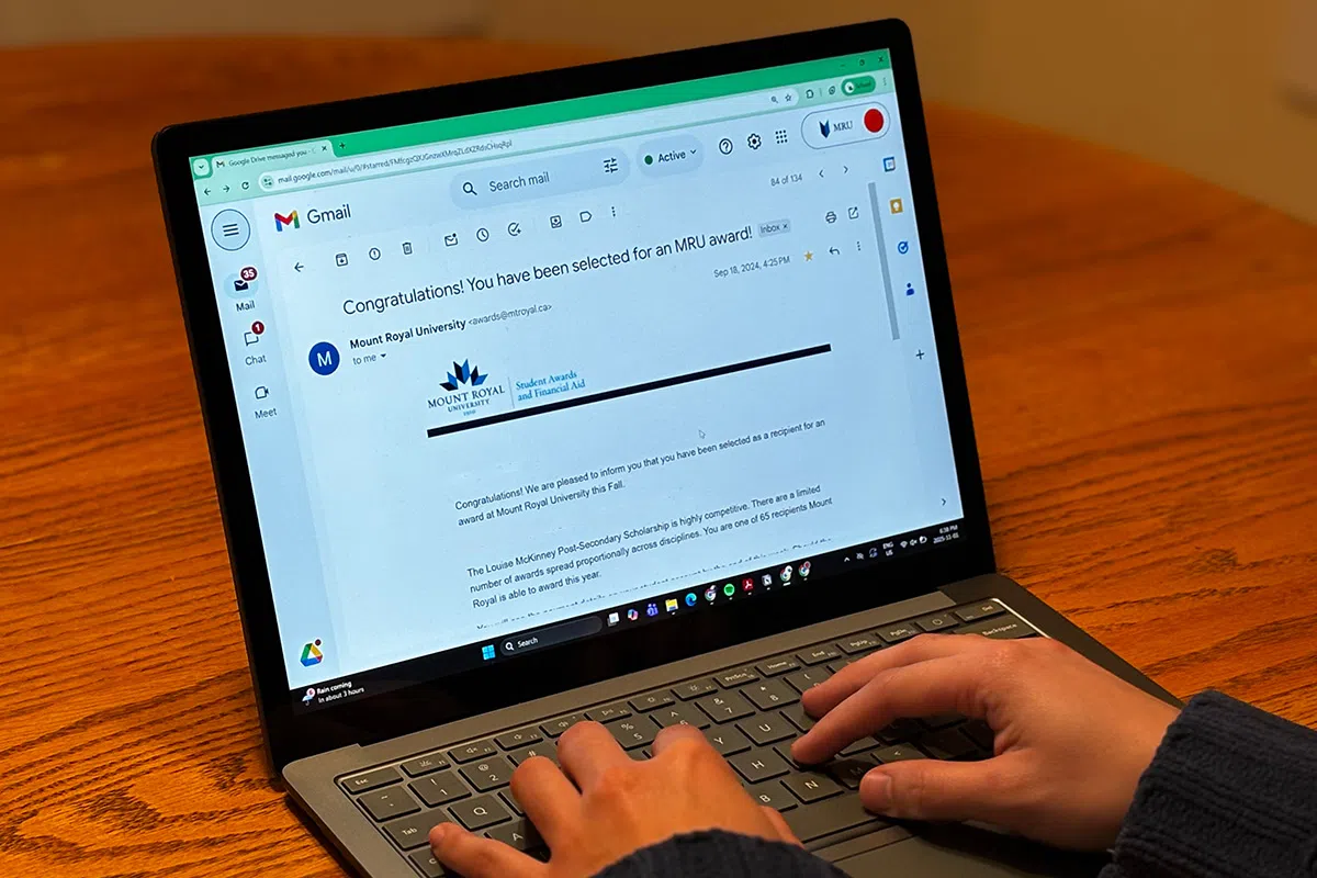 A laptop on a table with an email from Mount Royal University that says, Congratulations! You have been selected for an MRU award! in the subject line.