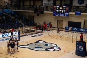 The Cougars Men's Volleyball team huddle up on the court in preparation for their potential game winning 4th set.