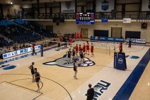 The Cougars and Dinos Men's Volleyball teams prepare for the match-deciding fifth set.