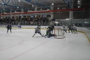 Huskies goalie Jordan Koozy makes a save on Cougars forward Alex Izyk.