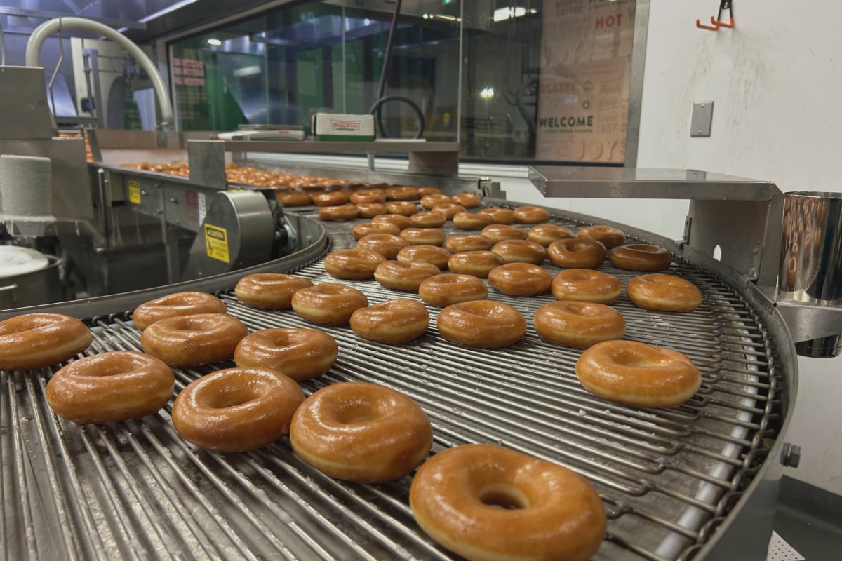 Original Glazed doughnuts move along the conveyor belt at Krispy Kreme's Macleod Trail location in Calgary, where fresh doughnuts are made for customers.