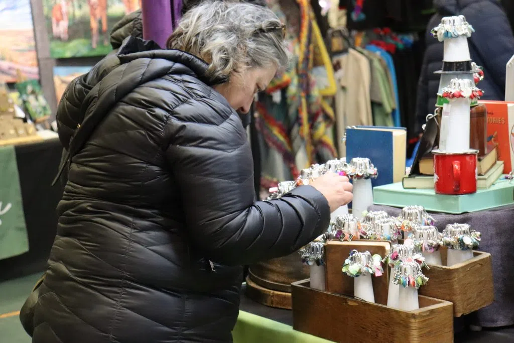 Shopper checking out an artisan table at the Butterdome Craft Sale (Photo Credits – Daniel Barker-Tremblay)