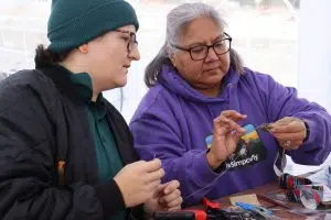 Parks Canada worker learning how to craft with Stoney Elder in Jasper