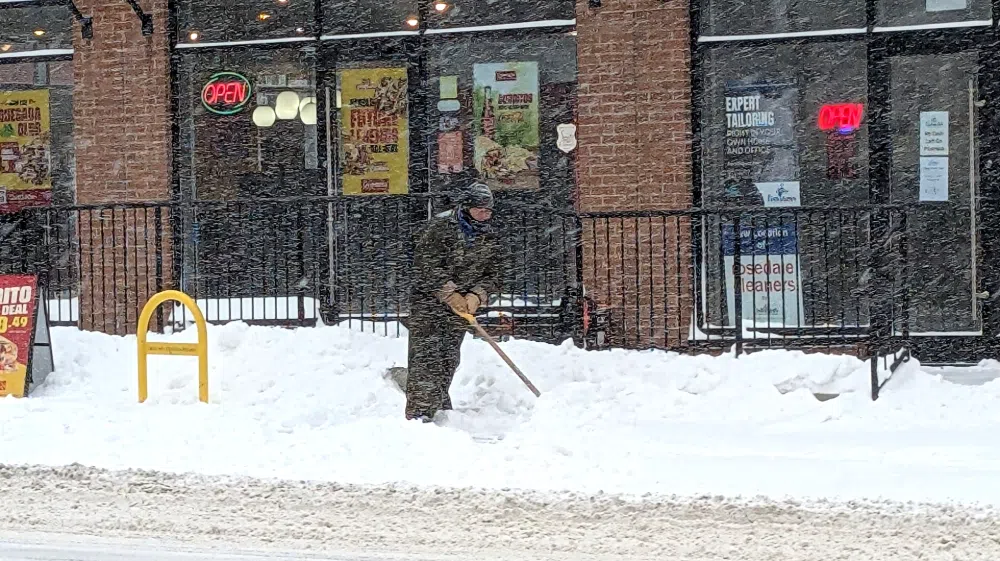 A person clearing snow in a snow storm
