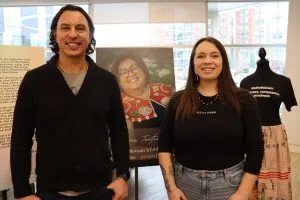 Jeremy Albert, Supervisor at Kihêw Waciston (Left), and Cheyenne Greyeyes, Student advisor (Right) in front of Ribbon Skirts Display (Photo Credits - Daniel Barker-Tremblay)