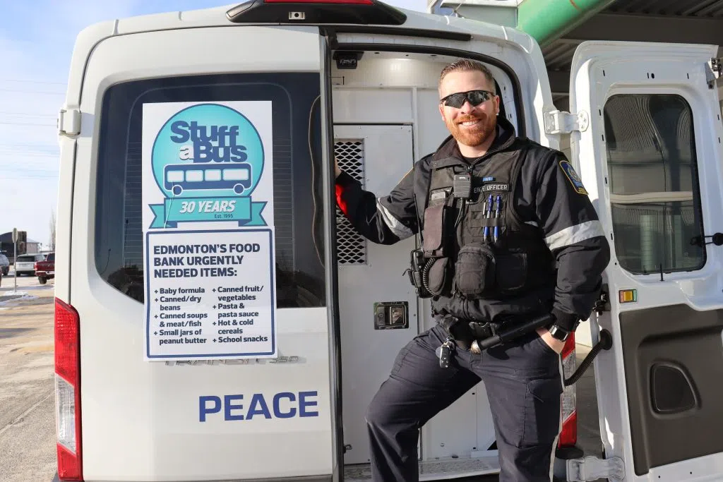 Edmonton Peace Officer Tom O'Neil all smiles on the back of the 'Stuff a Cruiser' in front of the Meadows Save on Foods in Edmonton (Photo Credits - Daniel Barker-Tremblay)