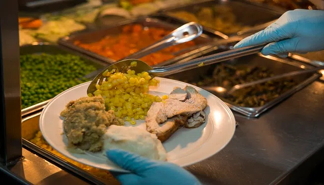 A U.S. Airman serves a plate of traditional food during a Thanksgiving Day celebration in the dining facility at Transit Center at Manas, Kyrgyzstan, Nov. 28, 2013. (U.S. Air Force photo by Senior Airman George Goslin/Released)