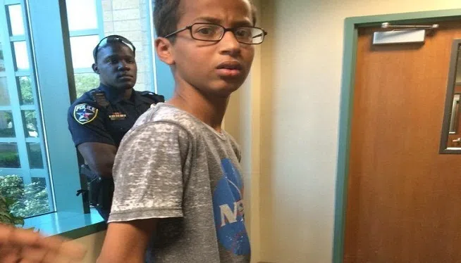 When Ahmed Mohamed went to his high school in Irving, Texas, Monday, September 14, 2015, he was so excited, he wanted to show his teacher the digital clock he'd made from a pencil case. But the 14-year-old's day ended not with praise, but punishment, after the school called police and he was arrested. A photo shows Ahmed, wearing a NASA t-shirt, looking confused and upset as he's being led out of school in handcuffs.