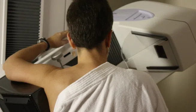 A woman stands while a mammogram is performed at an Atlanta hospital. keywords: breast cancer, mammography
