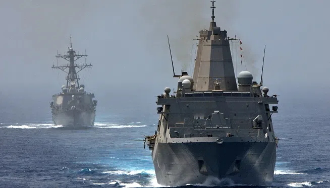 The San Antonio-class amphibious transport dock ship USS New York (LPD 21), front, and the Arleigh Burke-class guided missile destroyer USS Porter (DDG 78) transit the Strait of Hormuz. New York and Porter transited the strait with the Nimitz-class aircraft carrier USS Abraham Lincoln (CVN 72). New York is part of the Iwo Jima Amphibious Ready Group with the embarked 24th Marine Expeditionary Unit and is deployed supporting maritime security operations and theater security cooperation efforts in the U.S. 5th Fleet area of responsibility.