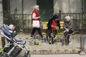 A woman talks with an elderly woman as she trims vegetables while sitting on a chair near a market in Beijing on April 11, 2016. China's consumer inflation was steady at 2.3 percent year-on-year in March, official data showed on April 11, a sign of stabilisation for the world's second-largest economy. / AFP / WANG ZHAO (Photo credit should read WANG ZHAO/AFP/Getty Images)