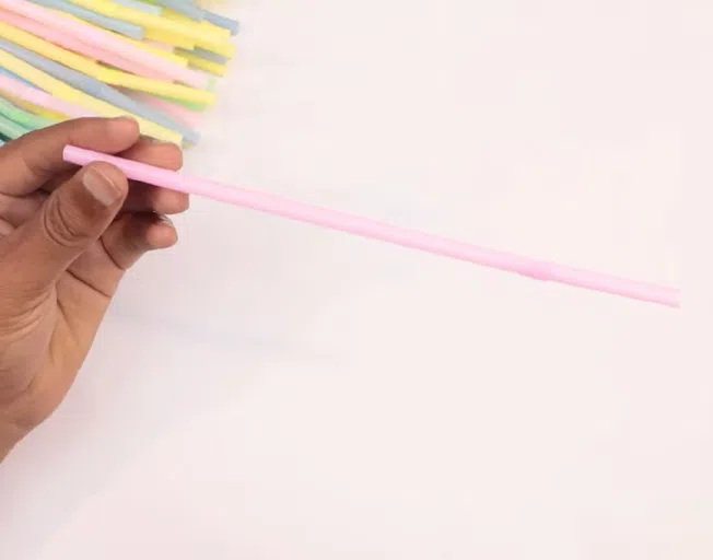 a hand holding a straw