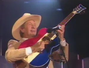 Buck Owens playing his signature red, white and blue guitar