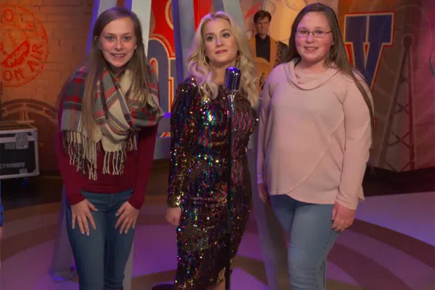 Kellie Pickler pretending to be a wax figure with fans standing next to her.
