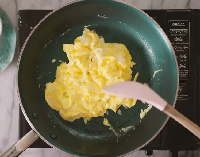 scrambled eggs cooking in a skillet