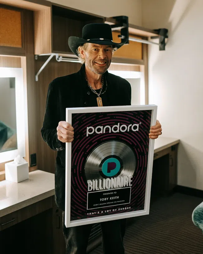Toby Keith holding a Pandora Billionaire plaque