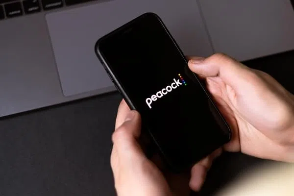 Peacock logo on smartphone screen. High quality photo.