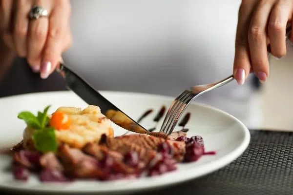 Female hands with a dinner at restaurant.