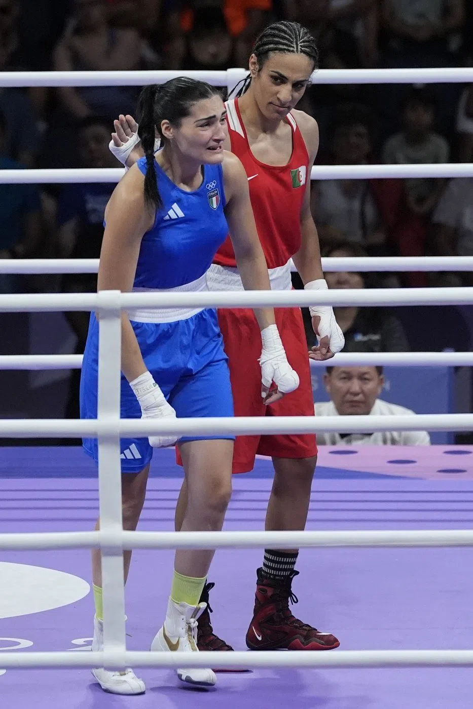 Algeria's Imane Khelif, red, next to Italy's Angela Carini, at the end of their women's 66kg preliminary boxing match at the 2024 Summer Olympics, Thursday, Aug. 1, 2024, in Paris, France. (AP Photo/John Locher)