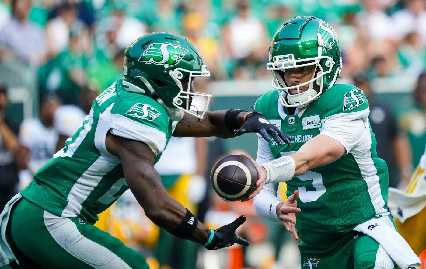 Saskatchewan Roughriders quarterback Shea Patterson (5) hands off to running back Frankie Hickson (20) during the first half of CFL football action against the Edmonton Elks in Regina, on Saturday, Aug. 3, 2024. THE CANADIAN PRESS/Heywood Yu