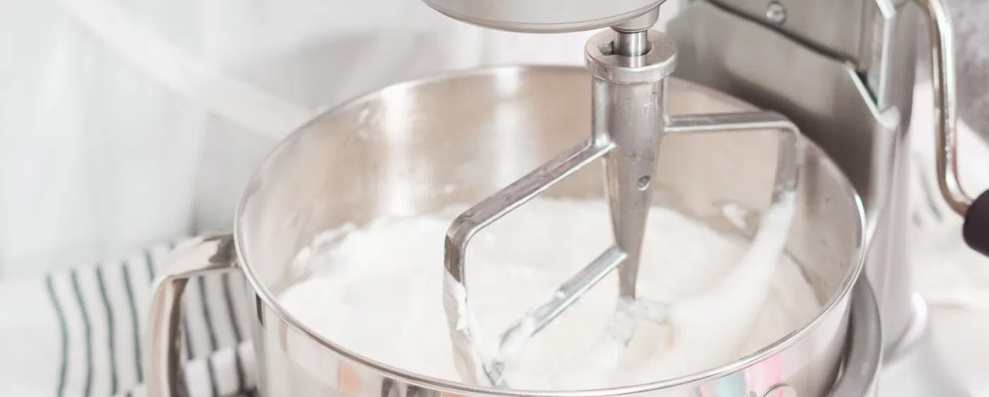 Icing being mixed in a stand mixer